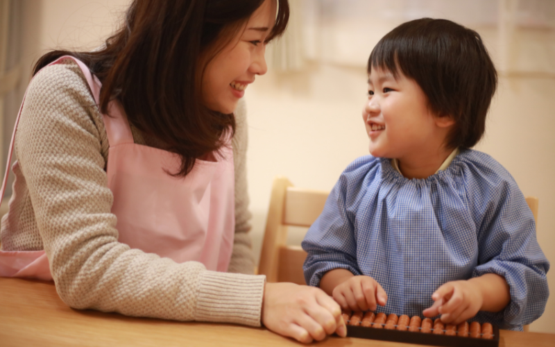 The image shows a mother and the boy learning abacus together.